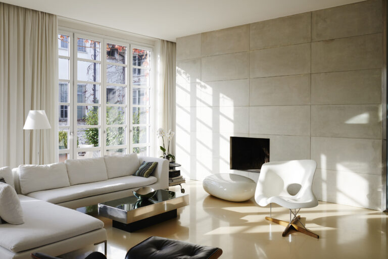 Soggiorno moderno con pavimenti in resina grigio chiaro effetto cemento, alternativa elegante ai pavimenti microcemento. Soluzione ideale per ambienti contemporanei, con indicazioni sul costo pavimento in resina per ristrutturazioni di interni.