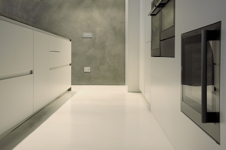 Soggiorno moderno con pavimenti in resina grigio chiaro effetto cemento, alternativa elegante ai pavimenti microcemento. Soluzione ideale per ambienti contemporanei, con indicazioni sul costo pavimento in resina per ristrutturazioni di interni.