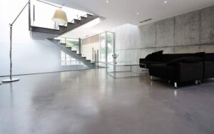 Soggiorno moderno con pavimento in resina effetto cemento grigio chiaro, soggiorno luminoso con resina continua senza fughe, design contemporaneo minimalista