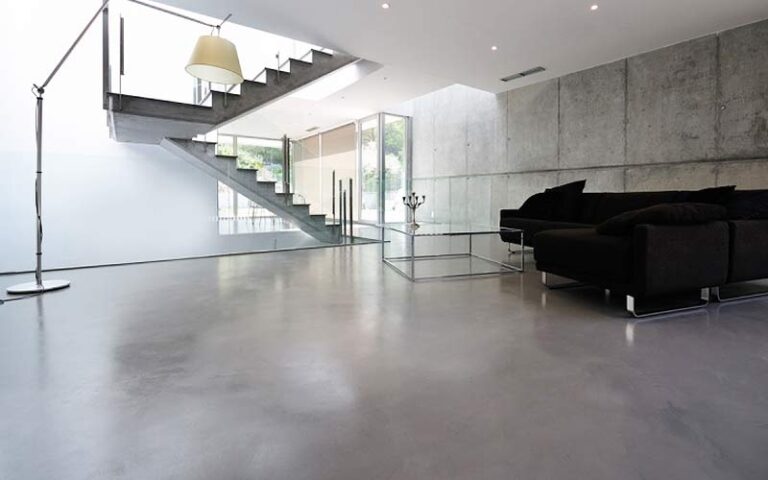 Soggiorno moderno con pavimento in resina effetto cemento grigio chiaro, soggiorno luminoso con resina continua senza fughe, design contemporaneo minimalista