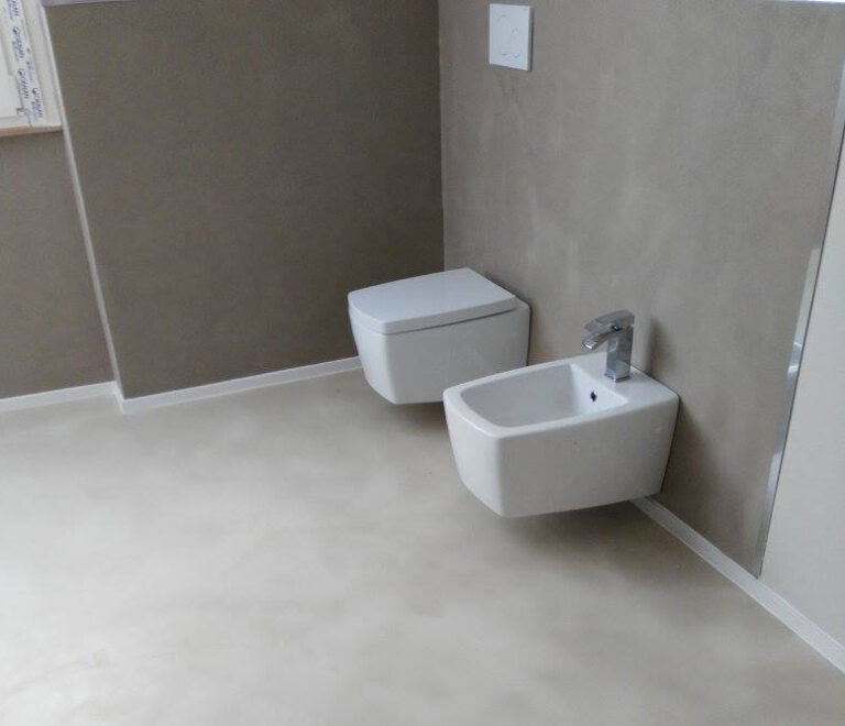 Bagno moderno con pavimento in resina effetto cemento grigio chiaro, soggiorno luminoso con resina continua senza fughe, design contemporaneo minimalista